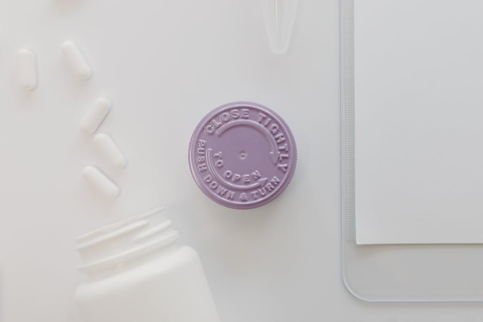 Close-up of a medicine bottle cap with pills on a white background, ideal for healthcare themes.