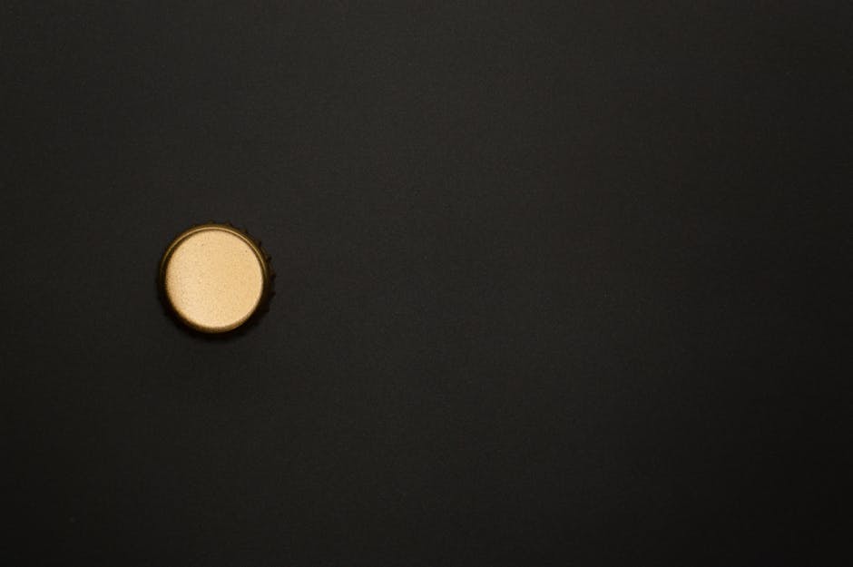 Close-up of a golden bottle cap on a black background with copy space.