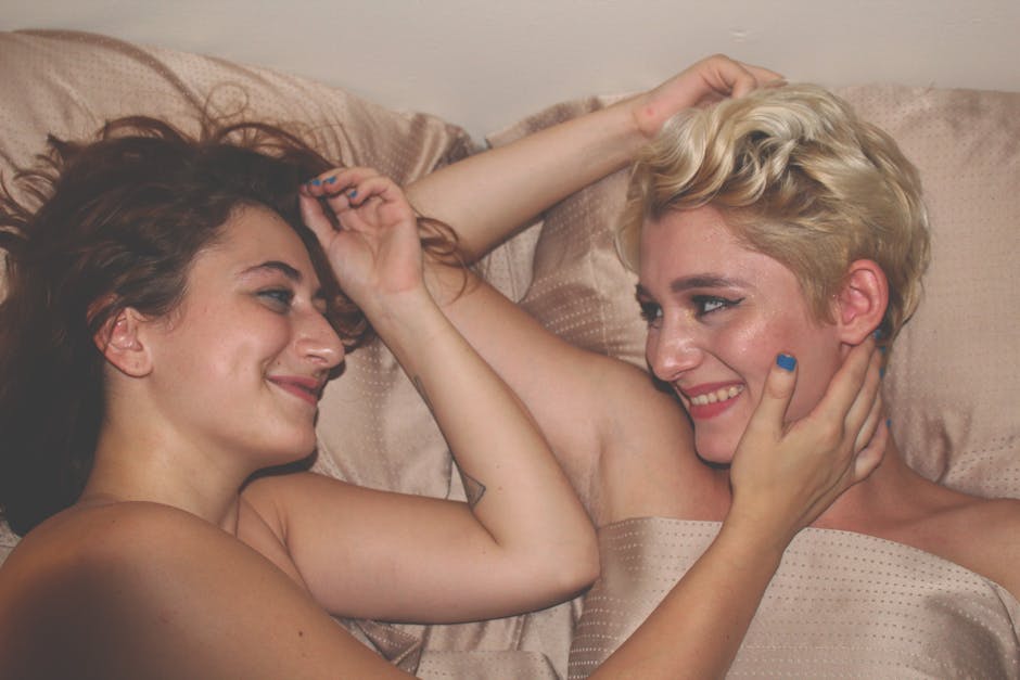 Two women sharing a tender, joyful moment in a bedroom setting.