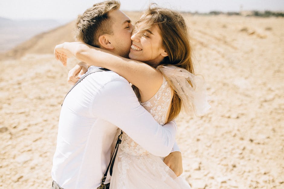 Happy couple embracing outdoors in a bright desert scene, filled with love and joy.