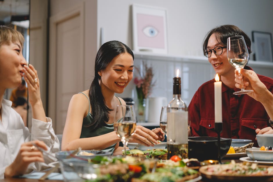 Friends enjoying a lively dinner party with wine and laughter by candlelight.
