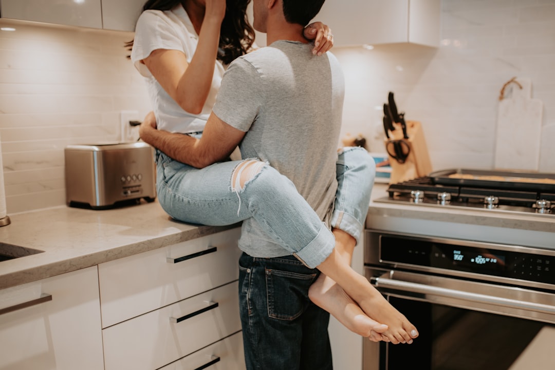 a man holding a woman in his arms in a kitchen