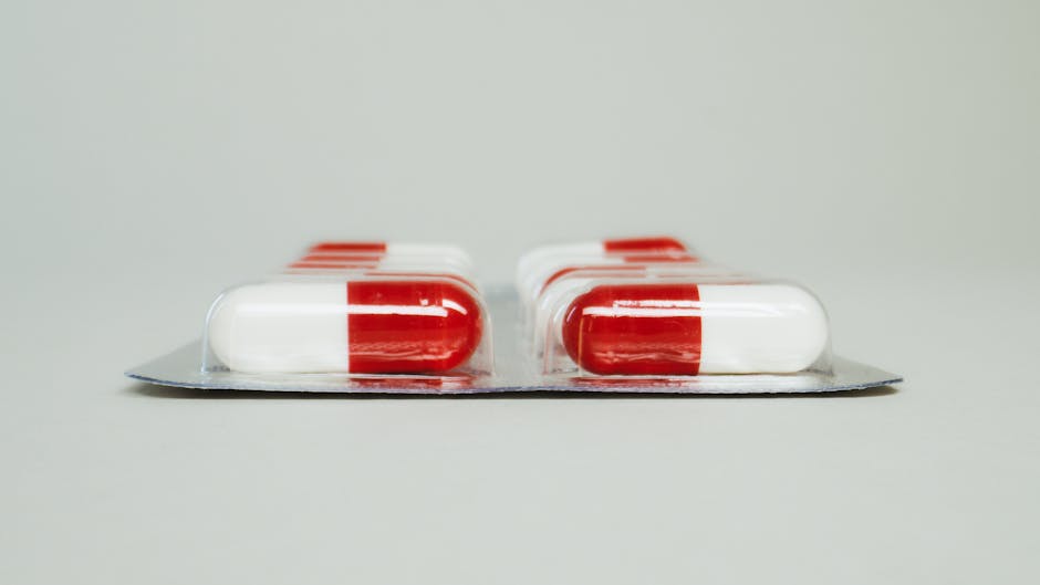 Blister pack of red and white capsules isolated against a simple background.