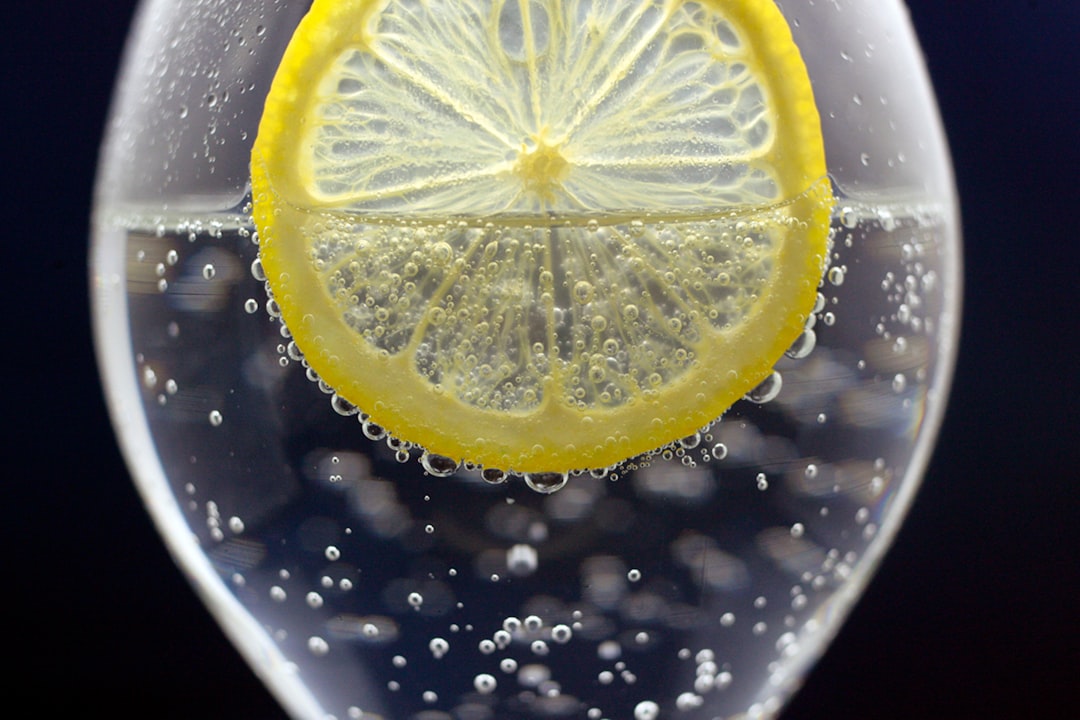 a glass of water with a lemon slice in it