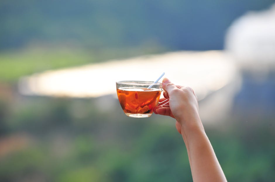 A peaceful moment enjoying tea outdoors with a beautiful blurred background.