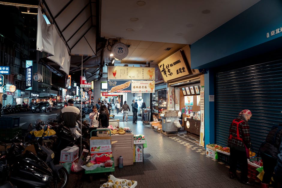 Bustling night market scene in Taipei, Taiwan, with vendors and locals shopping and dining.