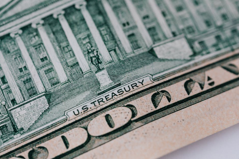 Detailed close-up of the U.S. Treasury text on a dollar bill, showcasing intricate design and financial symbolism.