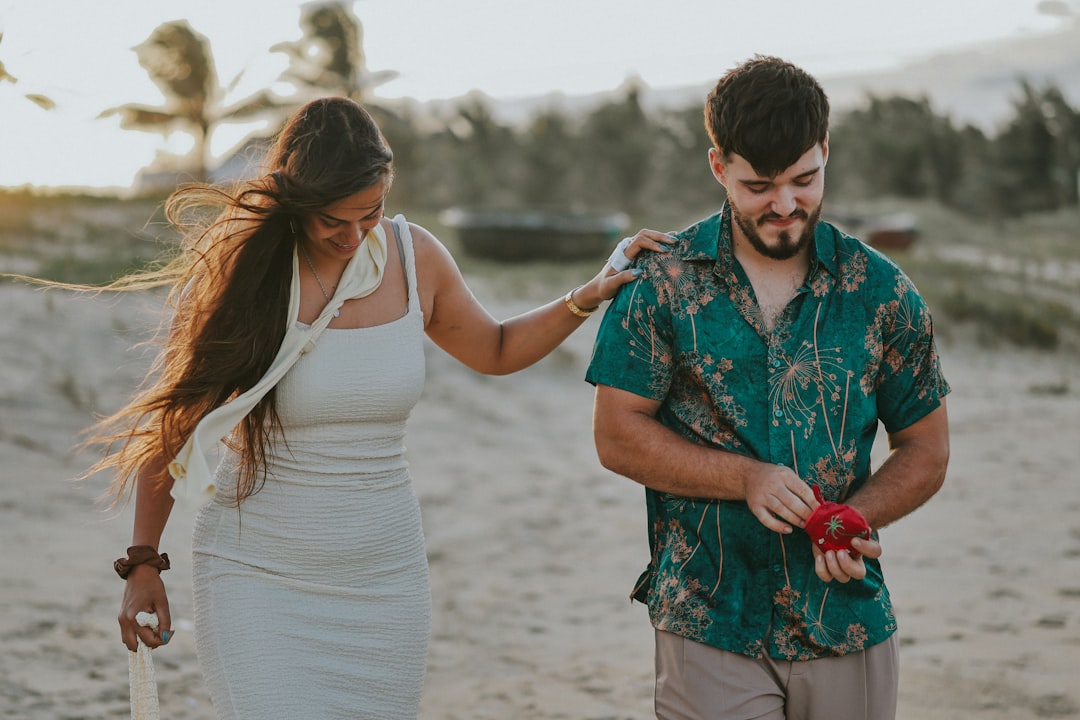 Couple walking on a sandy beach at sunset