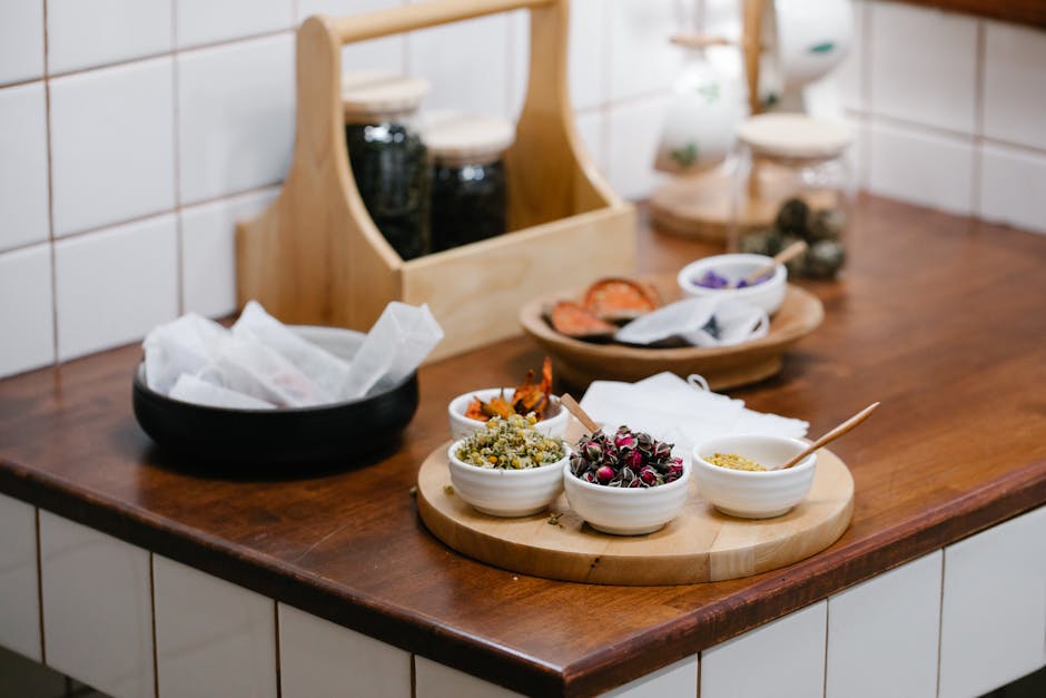 Close-up of various dried herbs and spices in bowls on a wooden kitchen counter.