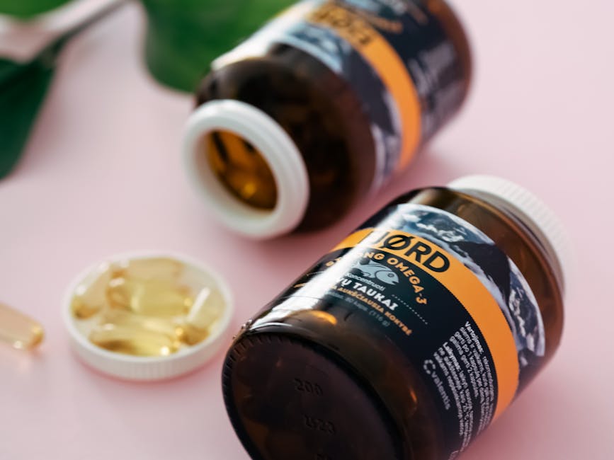 Close-up of Omega-3 fish oil capsules in transparent bottles on a pink background.