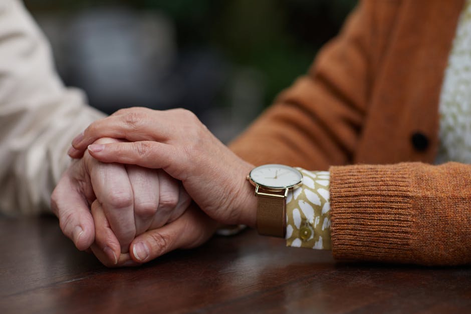 Close-up of a senior couple holding hands, symbolizing love and support.